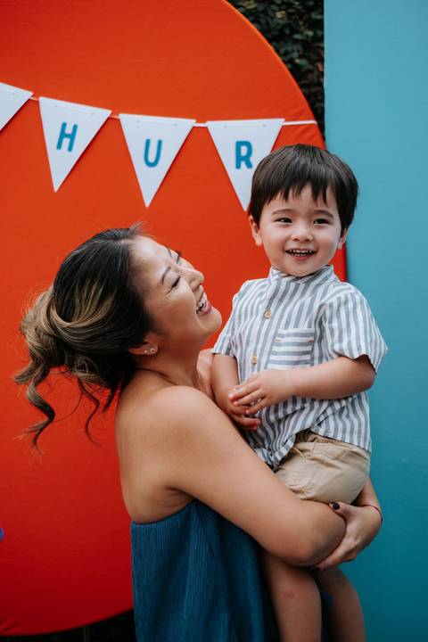 Foto da mãe olhando com adoração para o Arthur no colo.'