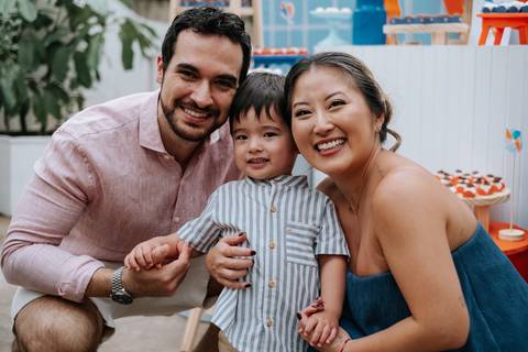 Foto oficial da família (pai, mãe e Arthur) sorrindo para a câmera.'