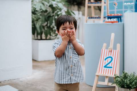 Foto do Arthur fazendo uma pose engraçada com as mãos no rosto.'
