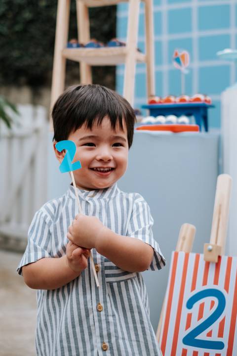 Foto de close do Arthur segurando um topper com o número 2.'