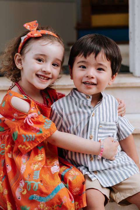 Foto do Arthur sorridente posando abraçado com uma convidada mirim.'