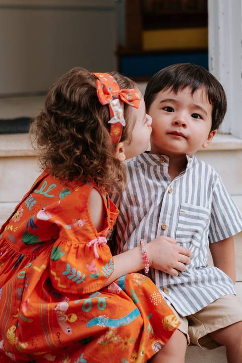 Foto do Arthur recebendo um beijo no rosto de sua amiguinha.'
