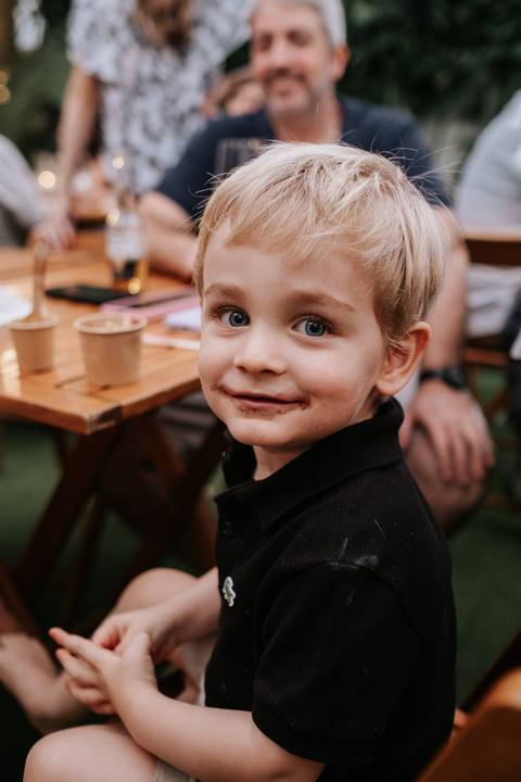Foto de close de um convidado mirim sorrindo para a câmera.'