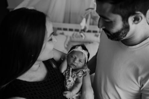 Foto em preto e branco do casal admirando a pequena Olívia.'