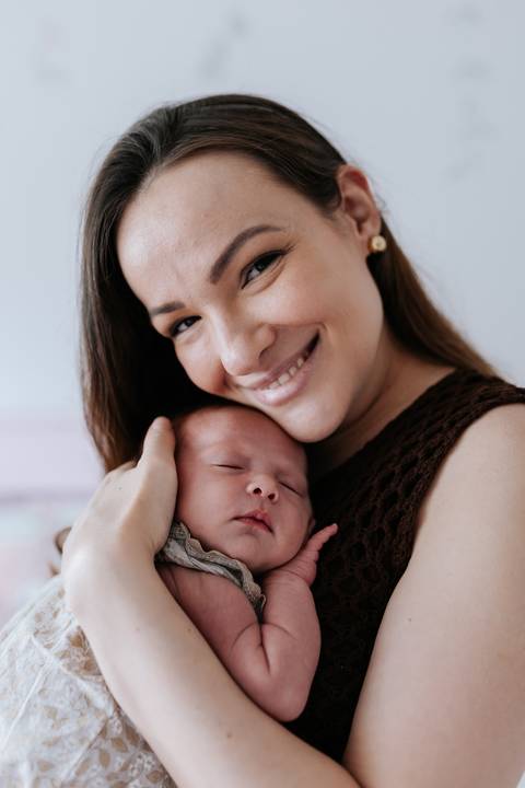 Foto de close da mãe encostando o rosto no da bebê.'