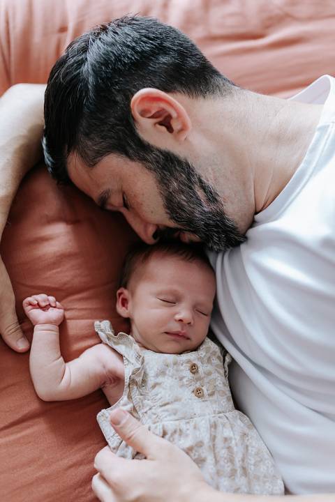 Foto de close do pai e Olívia dormindo encostados um ao outro.'
