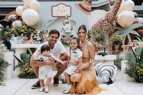 Foto da família reunida na mesa do bolo para o retrato oficial.'