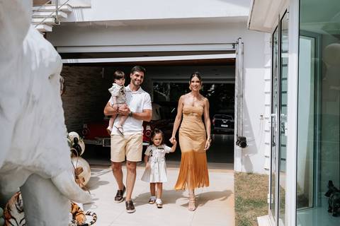Foto da família completa chegando ao evento em cenário externo.'