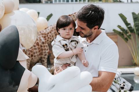 Foto do pai e filho interagindo com a decoração do Mickey.'
