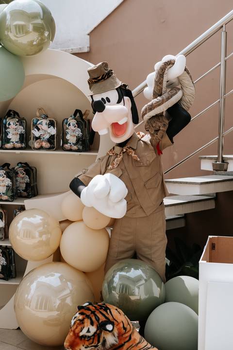 Foto de boneco do Pateta explorador decorando a escada do evento.'