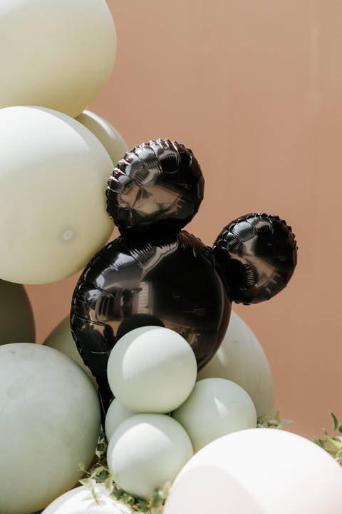 Foto em detalhe de balão metálico no formato da cabeça do Mickey.'