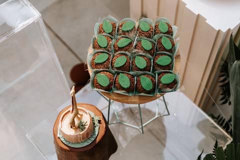 Foto aérea de docinhos gourmet decorados com mini folhagens.'