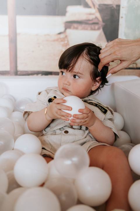 Foto de close do aniversariante concentrado segurando uma bolinha branca.'