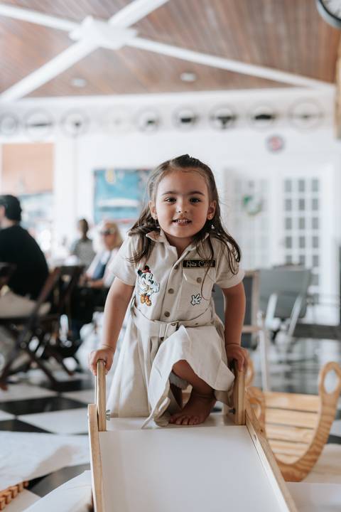 Foto de close da irmã do aniversariante sorrindo para a câmera.'