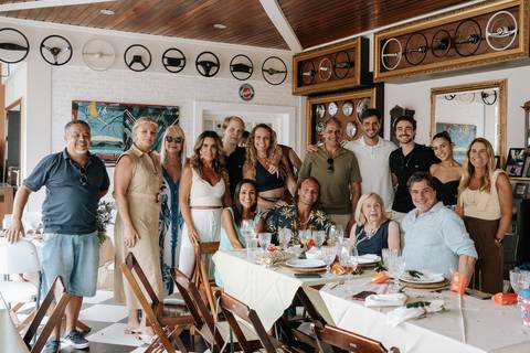 Foto oficial de grupo com familiares reunidos na mesa de jantar.'