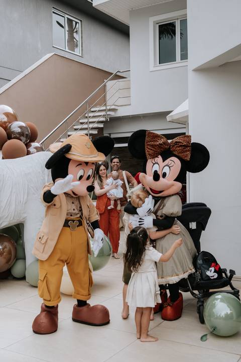 Foto dos personagens Mickey e Minnie Safari interagindo com a família.'