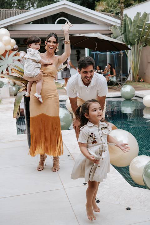 Foto da família reunida à beira da piscina durante a celebração.'