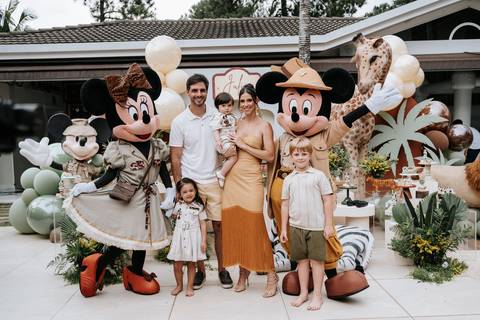 Foto oficial da família com o Mickey e a Minnie na mesa do bolo.'
