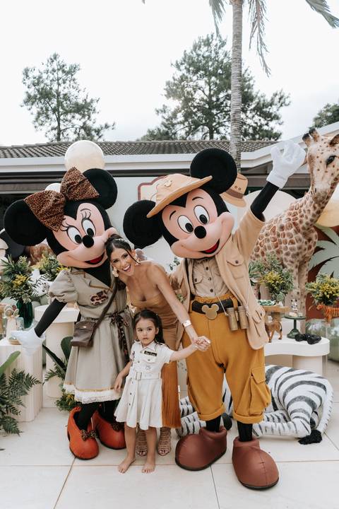 Foto da mãe e filhos posando com os personagens Safari.'