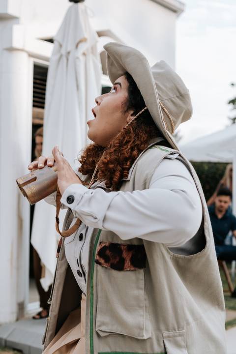 Foto de close da tia da gincana usando chapéu de explorador durante o evento.'