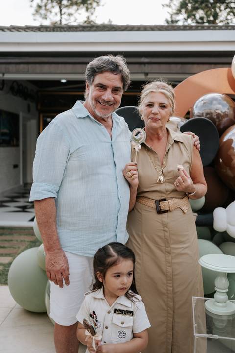 Foto dos avós sorridentes posando na decoração temática.'