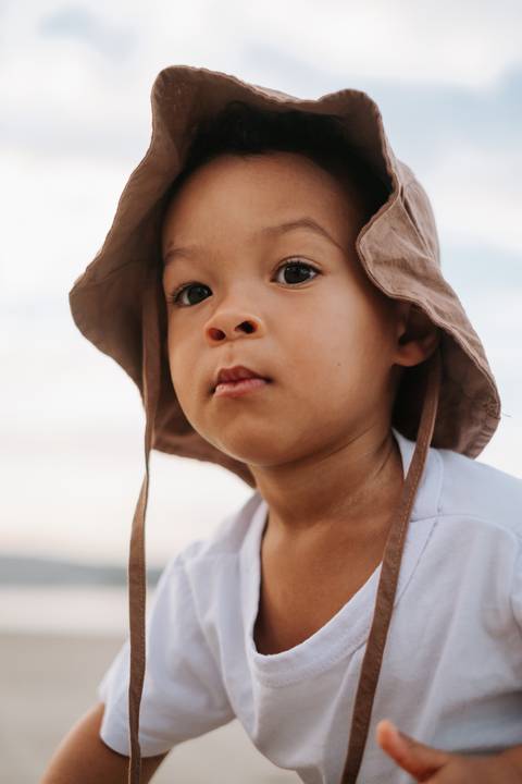 Foto do bebê olhando atentamente para a câmera com expressão curiosa.'