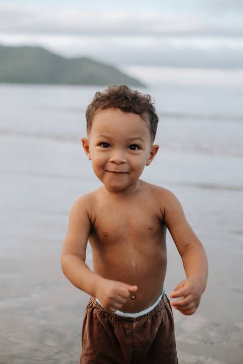 Foto de close do rosto do bebê sorrindo para a câmera.'
