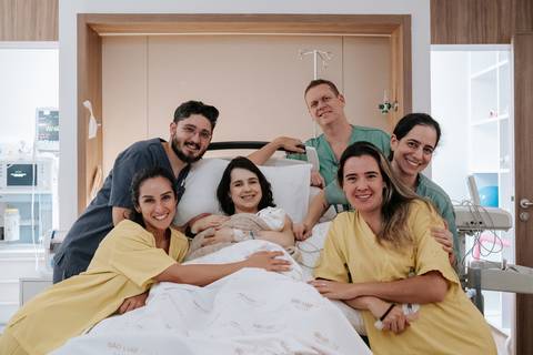 Foto oficial da família com toda a equipe multidisciplinar que assistiu o parto.'