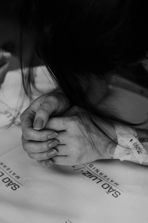 Foto em preto e branco de detalhe das mãos dadas, simbolizando apoio e força.'