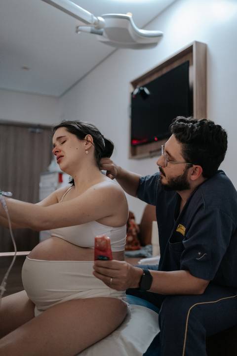 Foto do acompanhante massageando a nuca da gestante para promover relaxamento.'