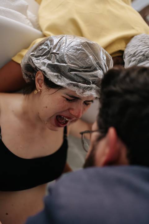 Foto de close da gestante durante o período expulsivo, demonstrando entrega e força.'