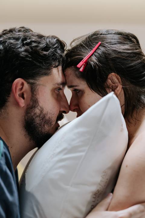 Foto de close do casal com as testas encostadas em um momento de profunda conexão.'