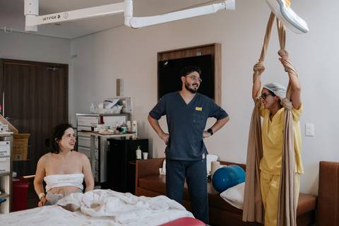Foto panorâmica da sala de parto com a gestante utilizando o tecido de apoio (rebozo).'