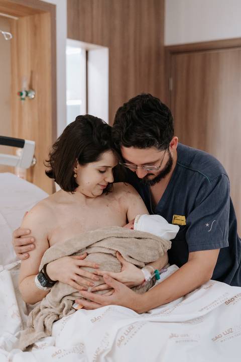 Retrato do pai orgulhoso segurando o bebê no colo para a câmera.'