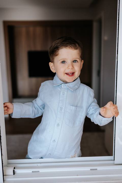 Foto do irmão mais velho sorrindo e animado com a chegada da família.'