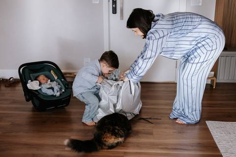 Foto da mãe e do filho mais velho recebendo o presente que o irmãozinho trouxe pra ele.
'