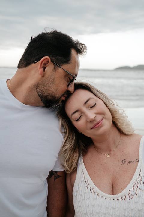 Close do casal em momento de ternura, com rostos encostados.'