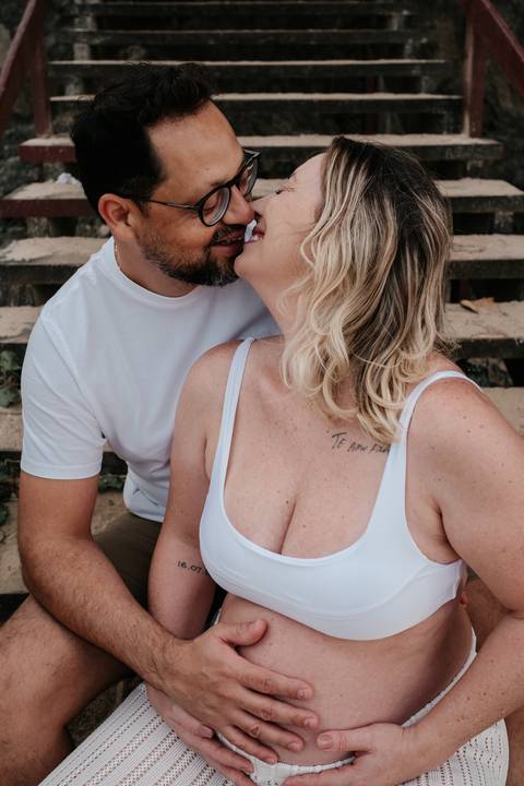 Foto de close do casal sorridente, com foco no rosto e na parte superior do corpo.'