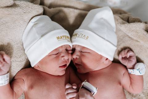 Foto aproximada dos rostinhos dos gêmeos Arthur e Pedro encostados, dormindo lado a lado.'