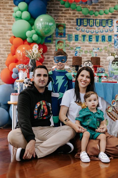 Outra linda pose da família unida, com o filho mais velho orgulhoso usando sua máscara de herói.'