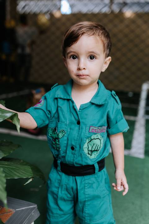 Close detalhado focando na camisa verde personalizada do caçula com estampas do Incrível Hulk.'