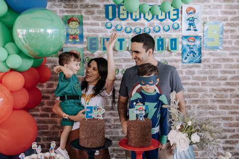Foto da comemoração logo após o parabéns, com os pais aplaudindo e comemorando com os filhos.'