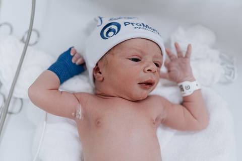 Foto de recém-nascido usando touca da maternidade após o nascimento'