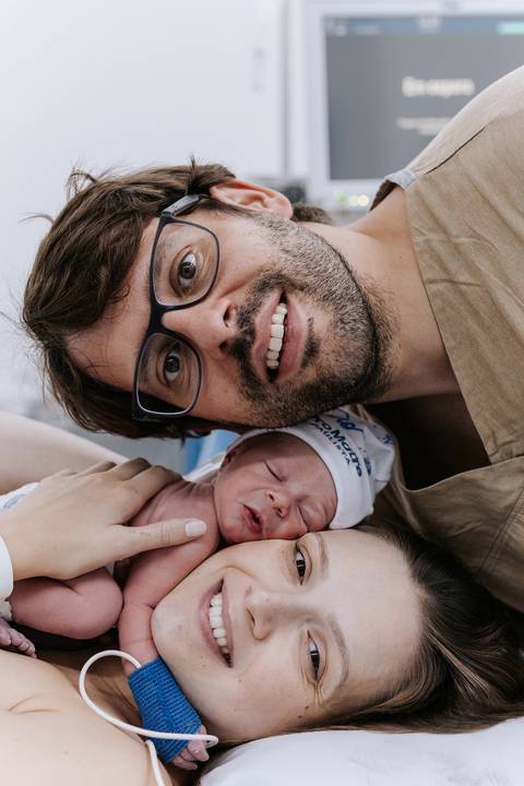 Foto de pai, mãe e filho juntos nos primeiros momentos de vida.'