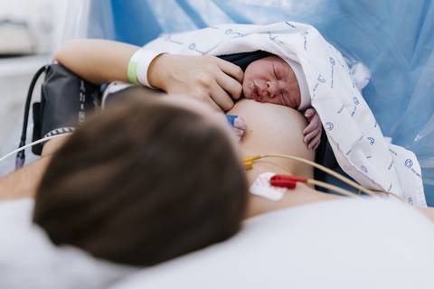 Foto de mãe segurando o recém-nascido nos primeiros minutos de vida'