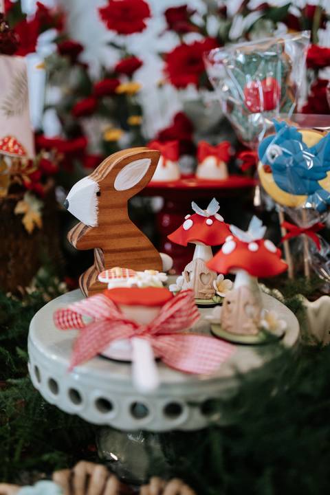 Detalhe dos doces decorados com cogumelos e esquilo de madeira.'