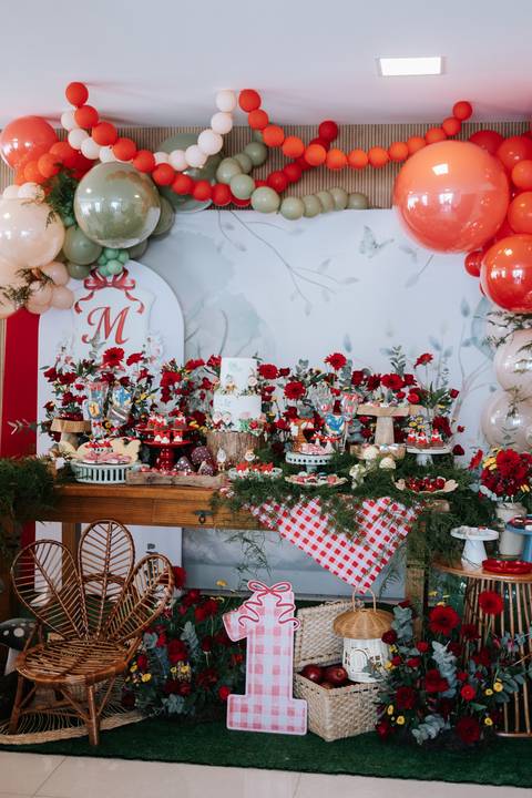 Foto panorâmica da mesa de doces principal decorada com o tema floresta.'