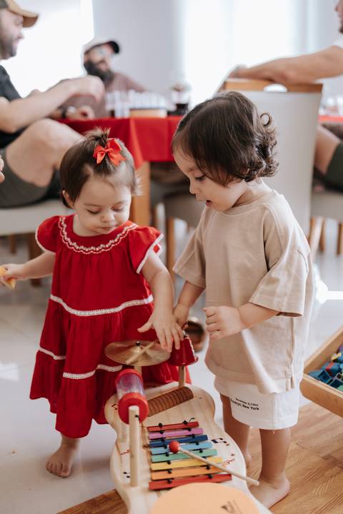 Registro espontâneo da aniversariante brincando no chão com outra criança.'