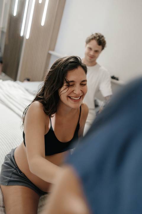 Registro da gestante sorrindo e descontraindo entre as contrações do parto.'
