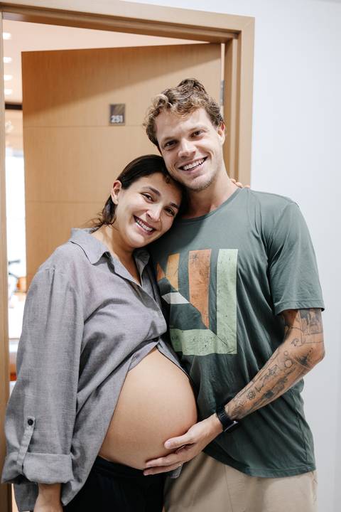 Casal abraçado e sorridente posando juntos em um momento de leveza.'